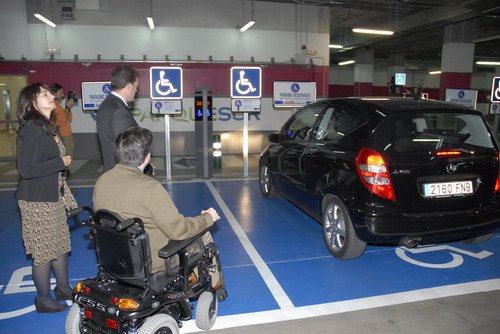 Personas observan un coche ocupando una plaza para PMR
